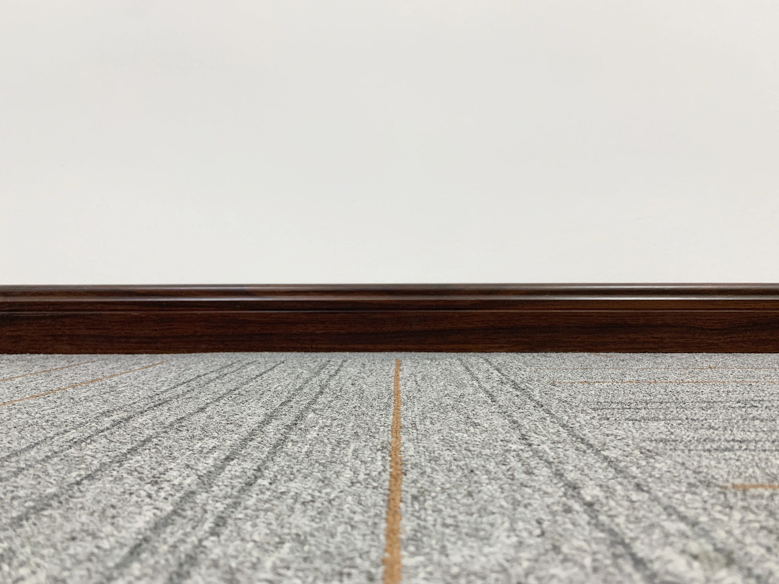 Carpet and baseboard detail in a home interior